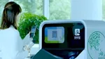 Woman holding plastic bottle ready to scan its QR code into an AI-enabled recycling and sorting machine.